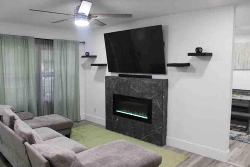 a living room with a fireplace and a flat screen tv at Cozy House Downtown Houston! in Houston