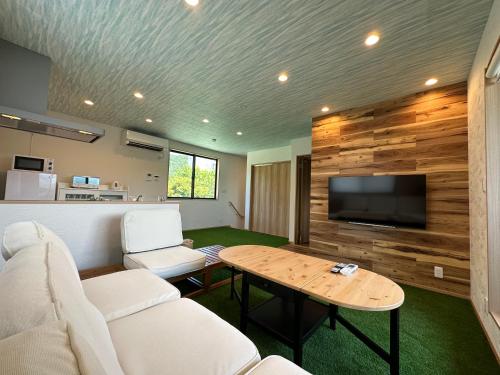 a living room with a white couch and a table at 09 Resort Club -Green- in Azagawa