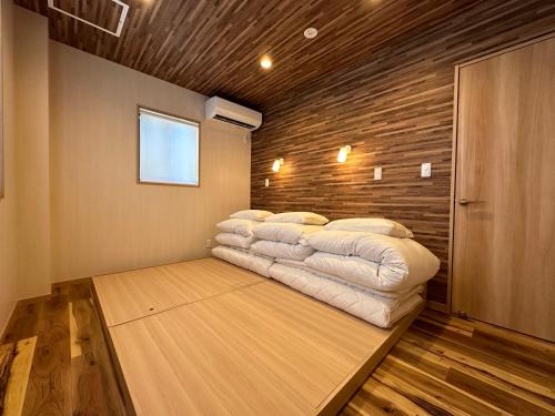 a bed in a room with a wooden wall at 09 Resort Club -Green- in Azagawa