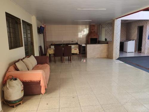 a living room with a couch and a kitchen at Quarto aconchegante na terra das cataratas in Foz do Iguaçu
