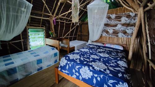 um quarto com uma cama e uma cadeira num quarto em Serenity Treehouse em Port-Olry