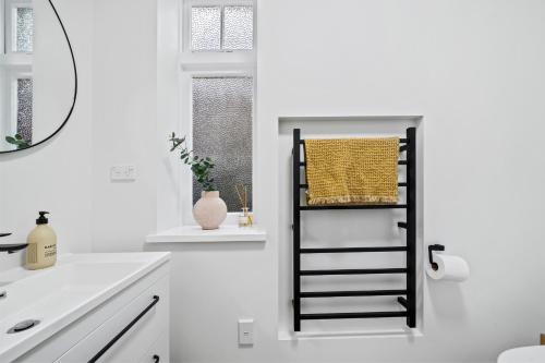 uma casa de banho branca com um toalheiro preto na parede em Capital Charm - Wellington Holiday Unit em Wellington