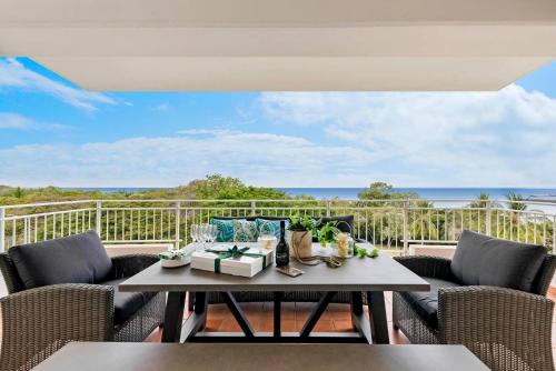a balcony with a table and chairs and the ocean at Harbour Haven - A Parkside CBD Address in Darwin