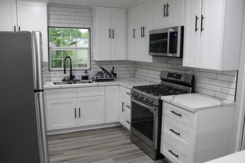 a kitchen with white cabinets and a stove top oven at Cozy House Downtown Houston! in Houston