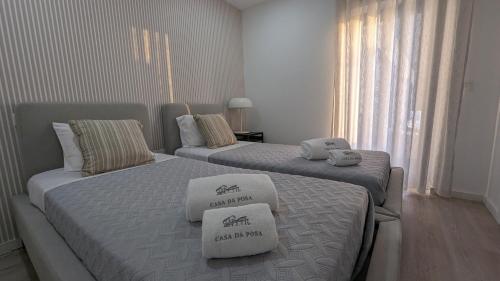 two beds in a hotel room with towels on them at Casa da Posa - AL - Férias com Piscina , Natureza e Perto do Centro de Ponte de Lima in Ponte de Lima