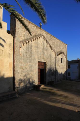 an old stone church with a cross on top of it at Brancadoria B&B in Monteleone Rocca Doria