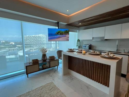 eine Küche mit einer Theke und einem TV an der Wand in der Unterkunft Marítima Golf Luxury Department 2BR in Bucerías