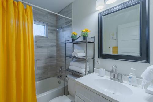 a bathroom with a sink and a tub and a mirror at Hidden Gem in San Antonio