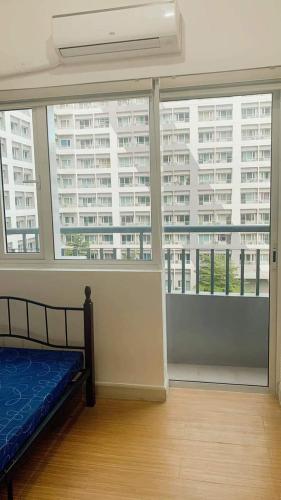 Cette chambre comprend un lit et une grande fenêtre. dans l'établissement Grace Residences Taguig City, à Manille