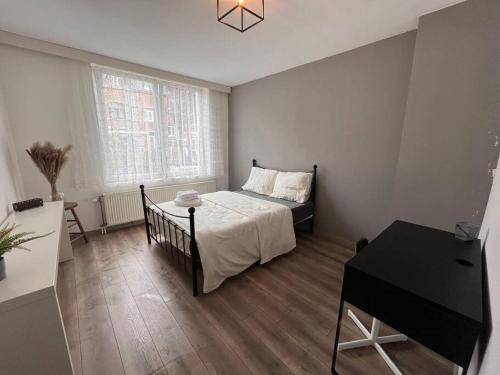 Un dormitorio con una cama y una mesa. en Appartement Verviers, en Verviers