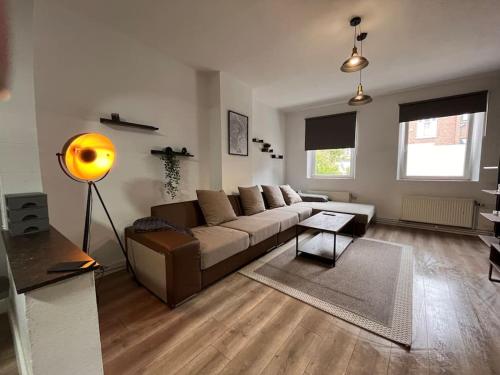 a living room with a brown couch and a yellow lamp at Appartement Verviers in Verviers