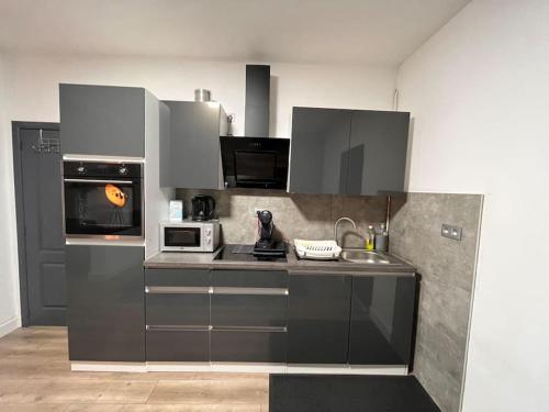 a kitchen with a counter with a microwave and a sink at Appartement Verviers in Verviers