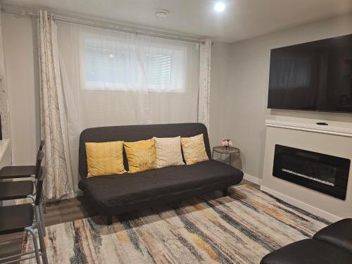 a living room with a couch and a fireplace at Cozy 2 Bedroom Suite, Queen Beds, Near the Airport in Edmonton