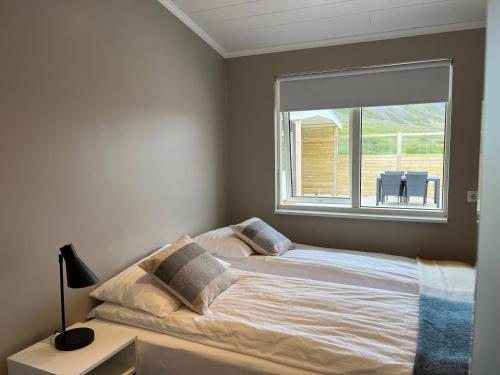 a bed in a bedroom with a large window at Strönd Guesthouse in Birkimelur 