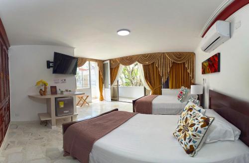 a hotel room with two beds and a television at HOTEL BOUTIQUE LUXURY in Cali