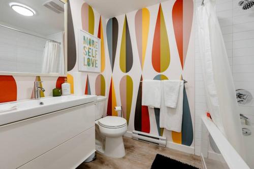 a bathroom with a toilet and a colorful wall at Hidden Gem: Historical Gastown in Vancouver
