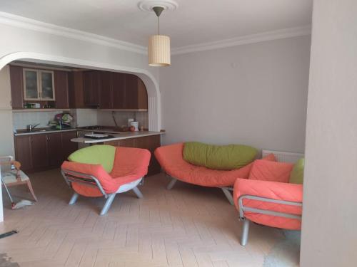 a living room with red and green chairs and a kitchen at Yalova star in Çınarcık