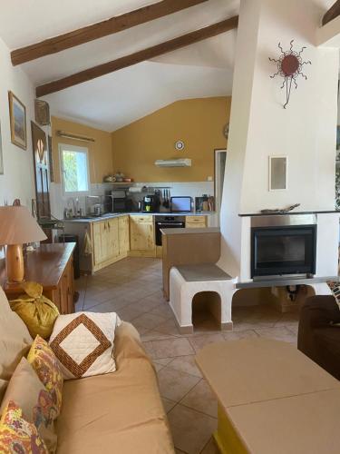 un salon avec un canapé et une cuisine dans l'établissement VILLA LARGIA porto vecchio - A 5 MIN DES PLAGES DE PALOMBAGGIA - CALME- CLIMATISATION, à Porto-Vecchio