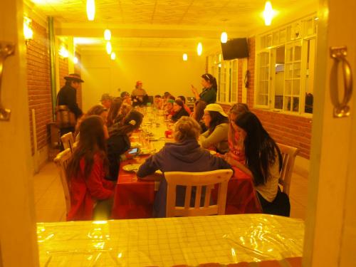 un groupe de personnes assises à des tables dans une pièce dans l'établissement EUCALYPTUS POTOSI, à Potosí