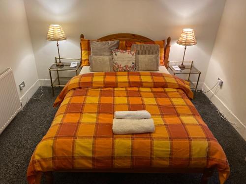 a bedroom with a large bed with two lamps at Grace's Home in Rotherham
