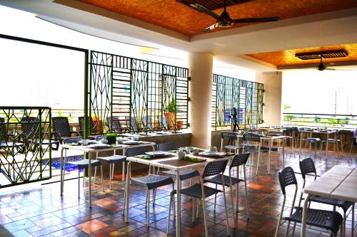 a restaurant with tables and chairs and large windows at XL / Penthouse 150m2 en Terrazas Tayrona 8-10 pax in Gaira