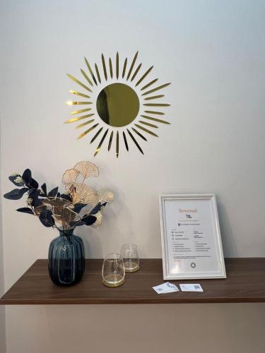 a mirror on a wall above a table with wine glasses at Amalfi Coast Casa Ida in Vietri sul Mare