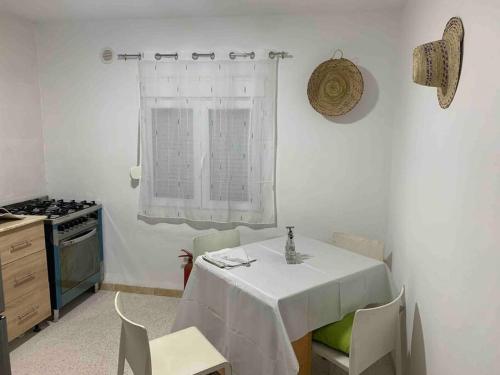 a kitchen with a table with a white table cloth on it at Appartement 5 lits climatisé salon 2chambres cuisine équipée SDB in Staoueli