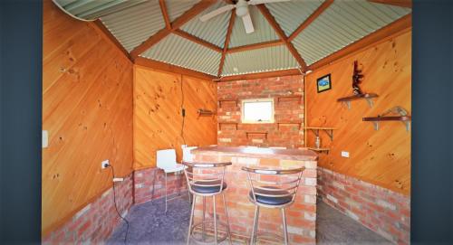 a room with a bar with stools in it at Whispering Woods House in Maryborough