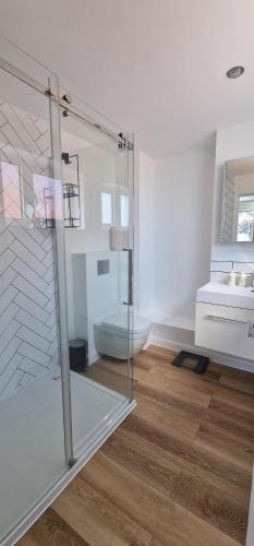 a bathroom with a glass shower and a sink at The Beach House in Kent