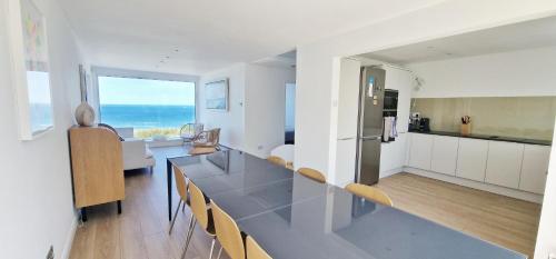 a kitchen and living room with a table and chairs at The Beach House in Kent