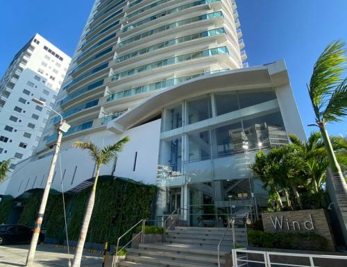 a tall building with palm trees in front of it at APARTAMENTO VISTA AL MAR WIND 906 in Gaira