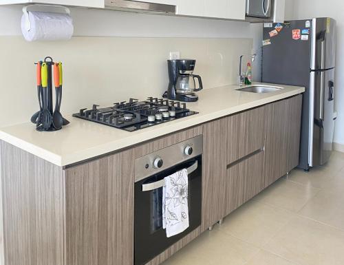 a kitchen with a stove top oven next to a refrigerator at APARTAMENTO VISTA AL MAR WIND 906 in Gaira