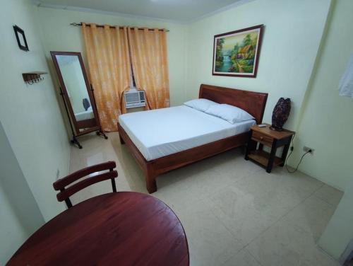 - une chambre avec un lit, une chaise et un miroir dans l'établissement Lawton Residences Studio Room 2F, à Manille