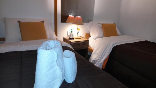 twee bedden in een hotelkamer met handdoeken erop bij Santa Matilde Hospedaje in Malargüe