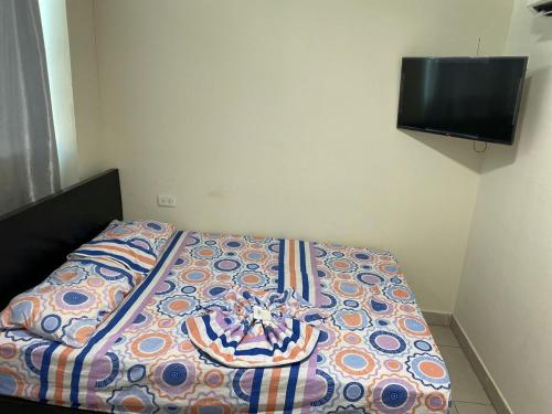 a bed with a colorful comforter in a bedroom at Hotel Gloria Del Norte in Cartagena de Indias