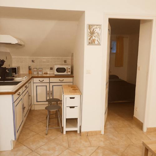 une cuisine avec des armoires blanches et un comptoir dans l'établissement Orpheus83, à Saint-Raphaël