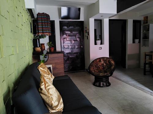 een woonkamer met een bank en een stoel bij Las viejitas, la casita más bonita del centro de Tuxtla Gutiérrez in Tuxtla Gutiérrez