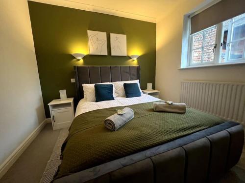 a bedroom with a large bed with blue pillows at Fully Equipped Queen Anne Court with FREE PARKING By Prescott Apartments in Abingdon