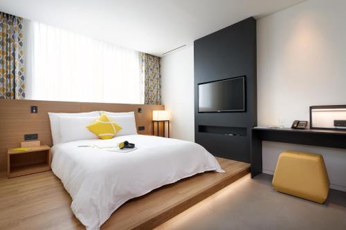 a hotel room with a bed and a television at L7 MYEONGDONG by LOTTE in Seoul
