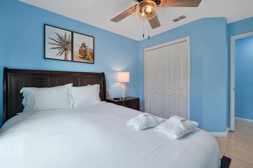 a bedroom with a large white bed with a ceiling fan at Luxury Villa in Orlando 4BD/3BA - 14 min Disney in Orlando