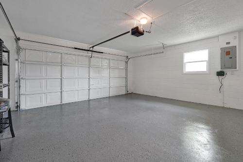 an empty garage with white garage doors and a window at Luxury Villa in Orlando with Pool - 10 min Disney in Orlando