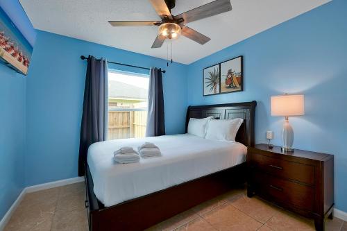 a blue bedroom with a bed and a ceiling fan at Luxury Villa in Orlando with Pool - 10 min Disney in Orlando