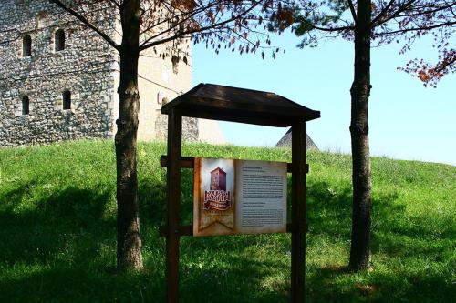 a sign in the grass next to two trees at Bajka in Valjevo
