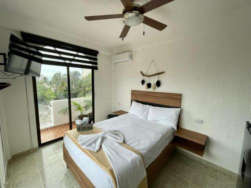 1 dormitorio con 1 cama y ventilador de techo en MAYAB Playa - 5Th. Ave en Playa del Carmen