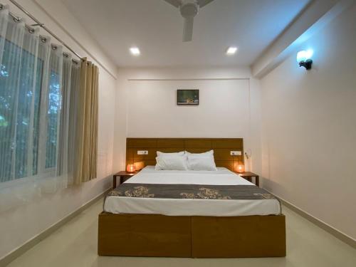 Un dormitorio con una cama grande y una ventana en Daffodils Luxury Airport Suites, en Angamaly
