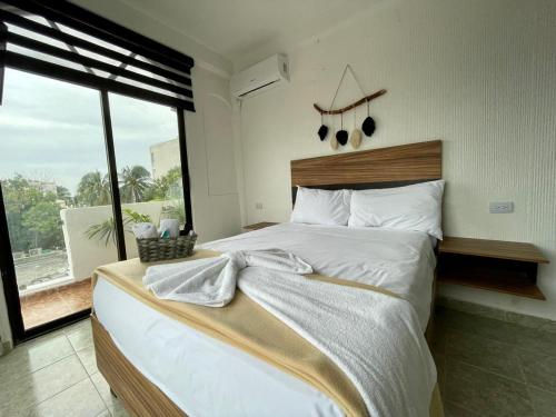 a bedroom with a large bed and a large window at MAYAB Playa - 5Th. Ave in Playa del Carmen