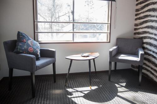two chairs and a table in a room with a window at Hotel Villa Hakuba by HHG in Hakuba
