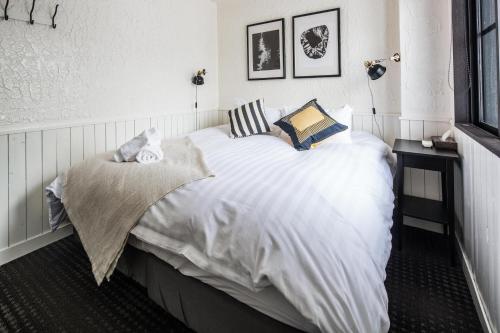 a bedroom with a large white bed with pillows at Hotel Villa Hakuba by HHG in Hakuba