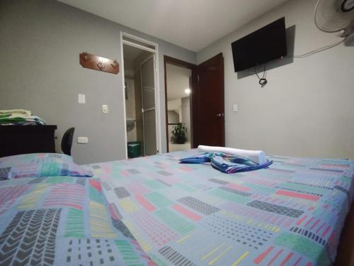 uma cama com um edredão colorido num quarto em HOTEL MARACANA em Bucaramanga