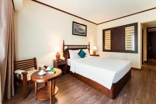 um quarto de hotel com uma cama, uma mesa e uma cadeira em Tran Vien Dong Hotel em Nha Trang